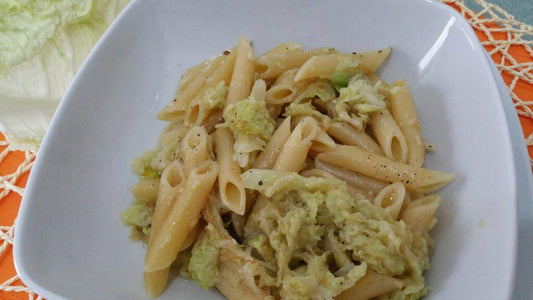 Pasta with cabbage dish served in a white bowl, garnished and ready to enjoy.