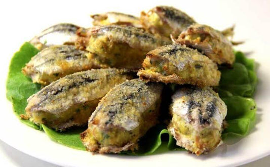 Stuffed anchovies on a bed of lettuce, a delicious Calabrian dish with a golden crust.