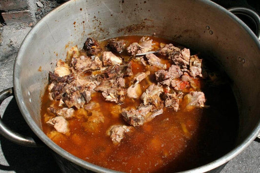 A pot of boiled goat meat stew with rich sauce and tender chunks of meat.