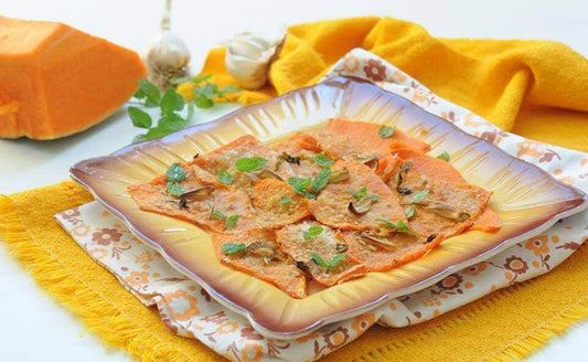 Plated zucca gialla dish garnished with fresh mint on a colorful tablecloth.