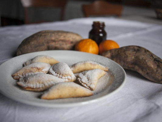 Delicious Buffeddhi della Magna Grecia pastries dusted with powdered sugar, served with sweet potatoes and honey.