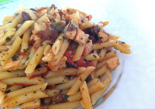 Delicious penne pasta with fish, tomatoes, and herbs, showcasing a vibrant Italian dish.