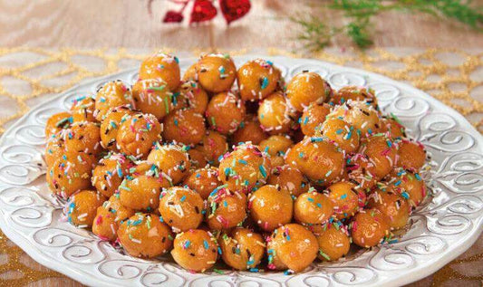 Traditional Pignolata di Carnevale, sweet Italian dessert with colorful sprinkles on a decorative plate.