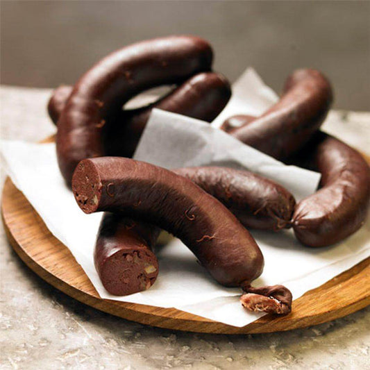 Sanguinaccio di maiale servito su un tagliere di legno, con un aspetto ricco e invitante.