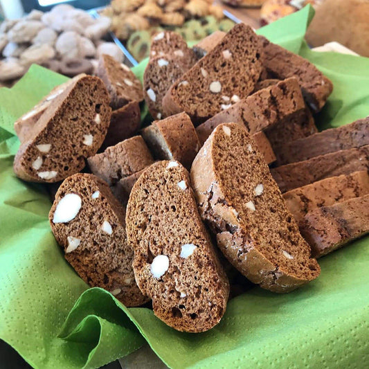 Deliciously baked Stomatico biscuits with almonds on green paper.