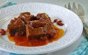 Delicious Capra di Calabria served with rich tomato ragù on a white decorative plate.