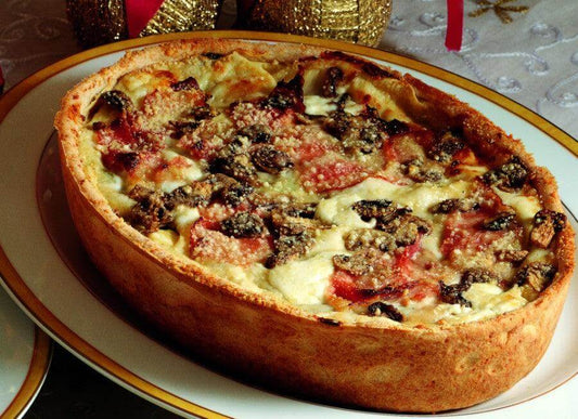 Traditional Pasticcio Toscano dish, baked and served in an oval plate, featuring layers of rich ingredients.