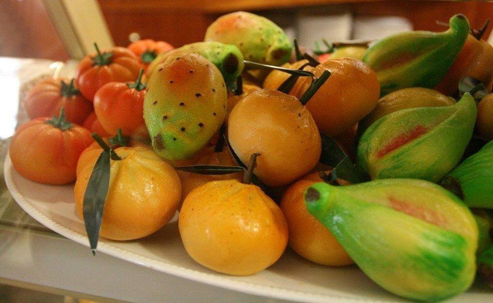 Colorful Sicilian Martorana fruits shaped like tomatoes and pears, made from almonds and sugar.
