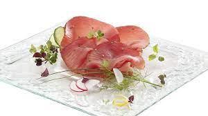 Bresaola di Tonno del Mediterraneo su un piatto elegante, guarnita con erbe fresche e verdure.