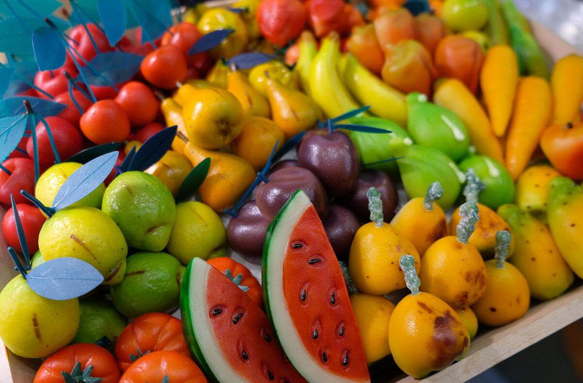 Colorful assortment of Sicilian Martorana fruits, including watermelons, bananas, and other vibrant sweets.