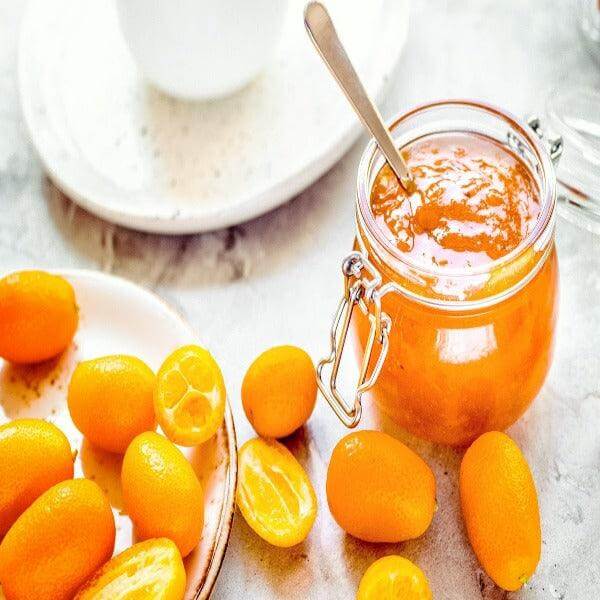 Delicious kumquats and jar of kumquat jam on a marble surface, perfect for decoration and flavor.