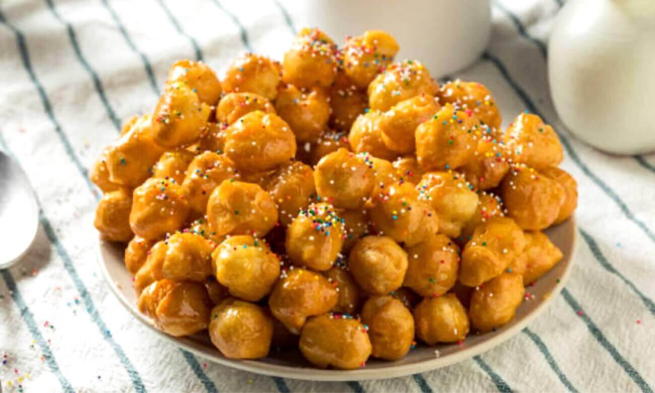 Pignolata di Carnevale tradizionale, dolce calabrese e siciliano con miele e zuccherini colorati.