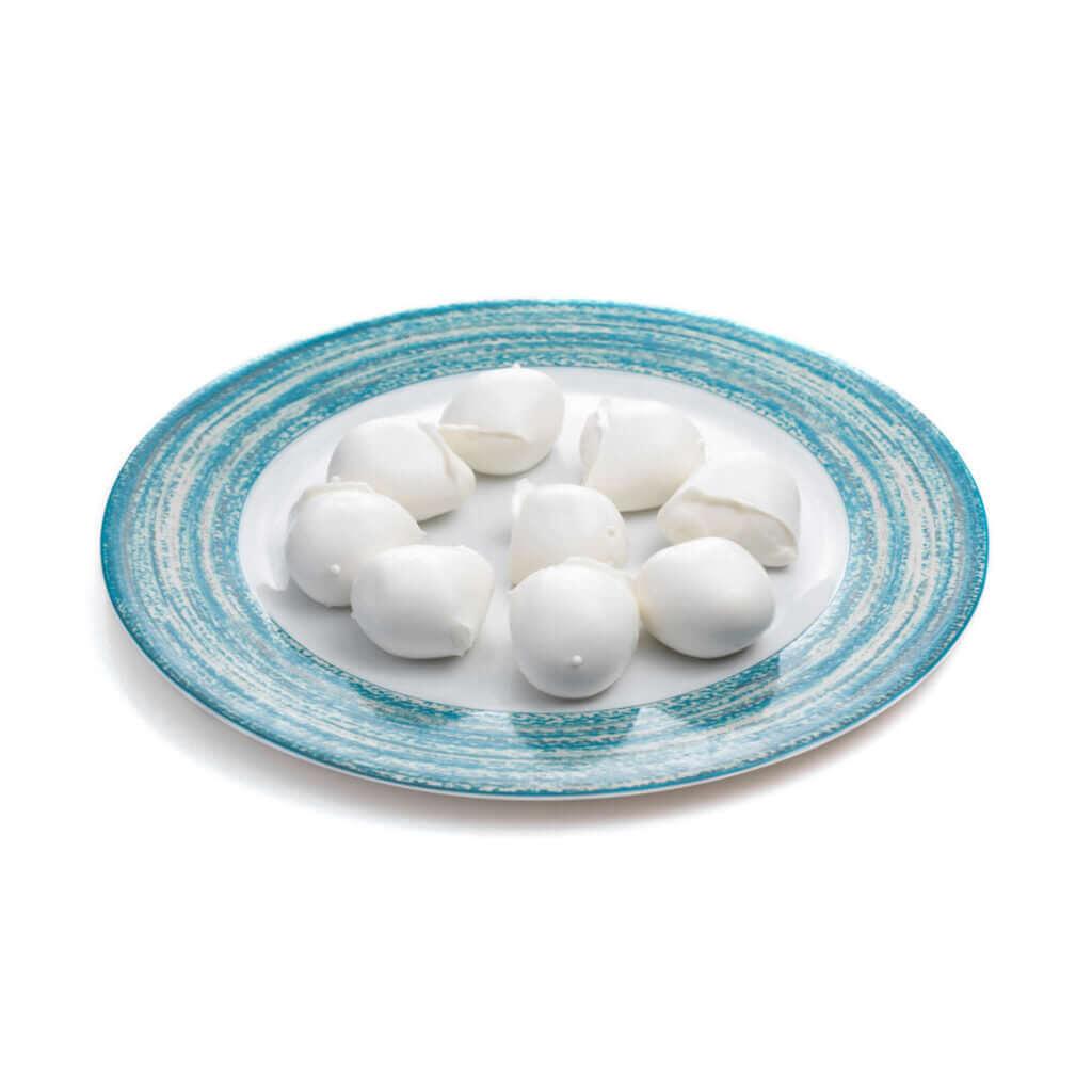 Bocconcini mozzarella bufala campana DOP on a blue and white plate, showcasing fresh Italian cheese delicacies.