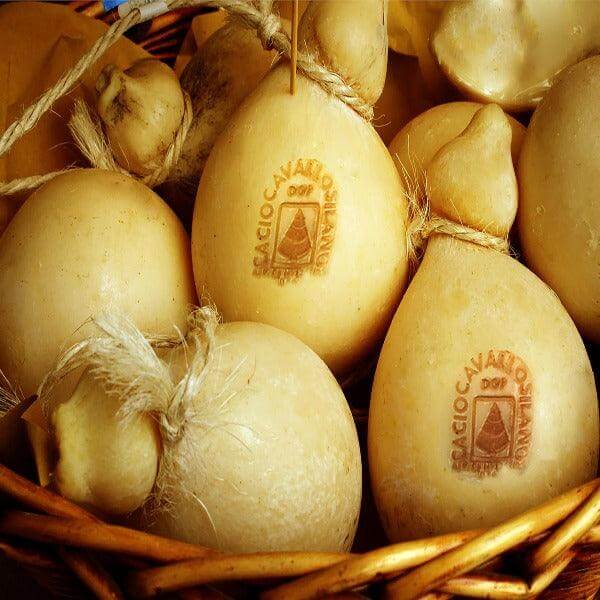 Caciocavallo Silano DOP cheese in a basket, showcasing its pear shape and smooth rind.