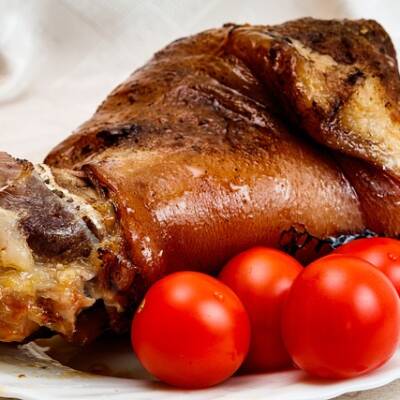 Stinco di maiale cotto al Cirò Rosso DOCG con pomodorini freschi.