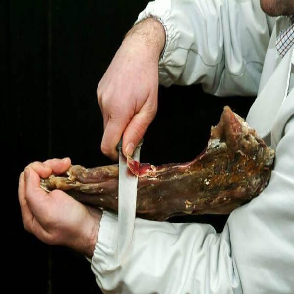 Preparazione del Violino di Capra dìAspromonte con coltello, tagliando prosciutto di capra.