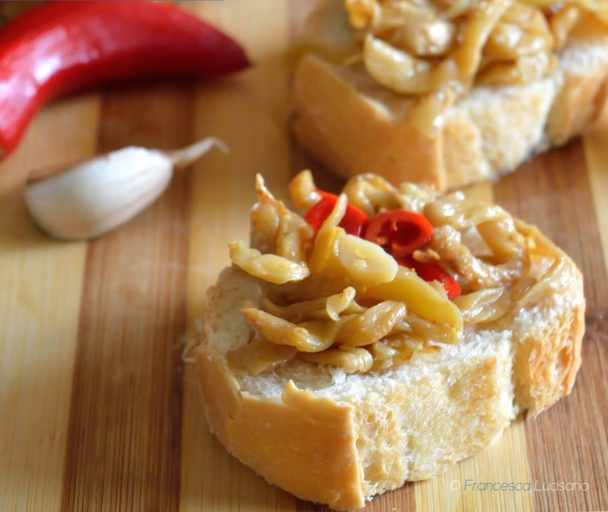 Delicious Melanzane a Filetti on bread, garnished with chili, garlic, showcasing traditional Calabrese flavors.
