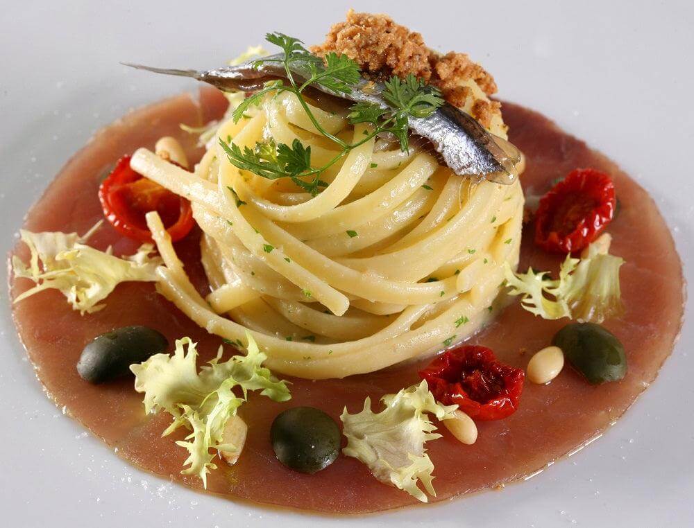 Delicious spaghetti topped with anchovies, sun-dried tomatoes, and herbs, perfect for Colatura di Alici.