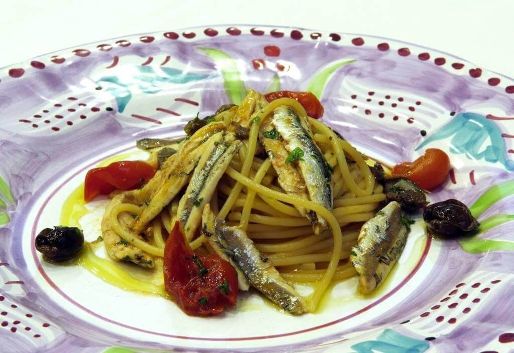 Pasta with anchovies and cherry tomatoes, a dish enhanced by Colatura di Alici for Mediterranean flavor.