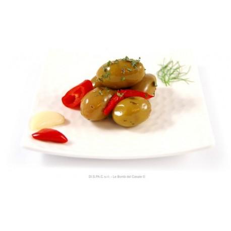 Olive verdi della Nonna - verdi schiacciate con aglio, carote, peperoni, e prezzemolo su piatto bianco.