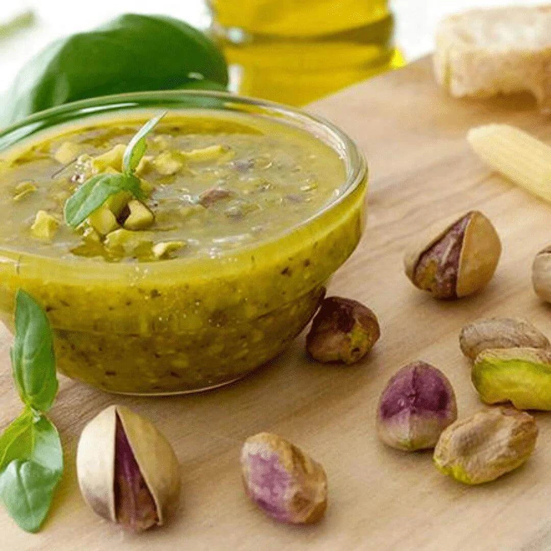 Pesto di Pistacchio Sicilia in olio di oliva artigianale, servito in ciotola con pistacchi e basilico.