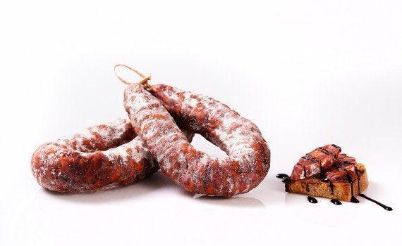 Salsiccia Curva Calabrese accanto a un piatto di pane alla griglia con salsa.