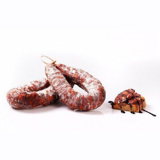 Salsiccia Curva Calabrese accanto a un piatto di pane alla griglia con salsa.