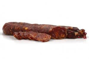 Salsiccia Grecanica Calabrese stagionata ed affumicata naturalmente con fette su sfondo bianco.