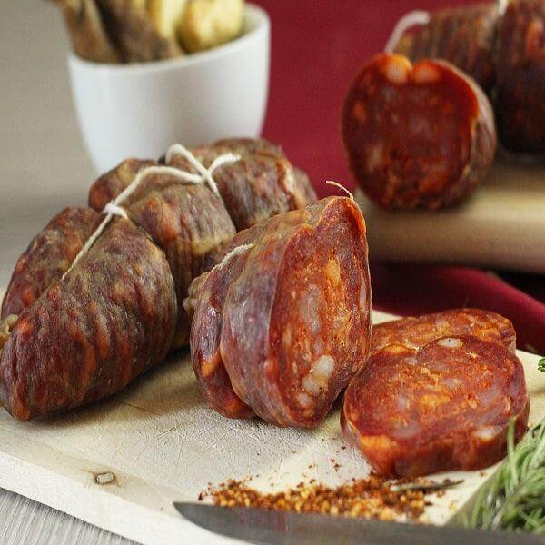 Authentic Soppressata Calabrese displayed on a wooden board, showcasing its rich color and texture.
