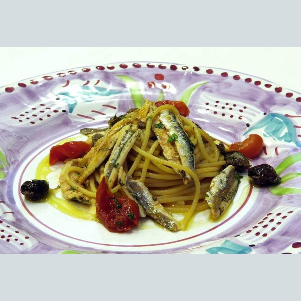 Pasta with anchovies and cherry tomatoes, a dish enhanced by Colatura di Alici for Mediterranean flavor.