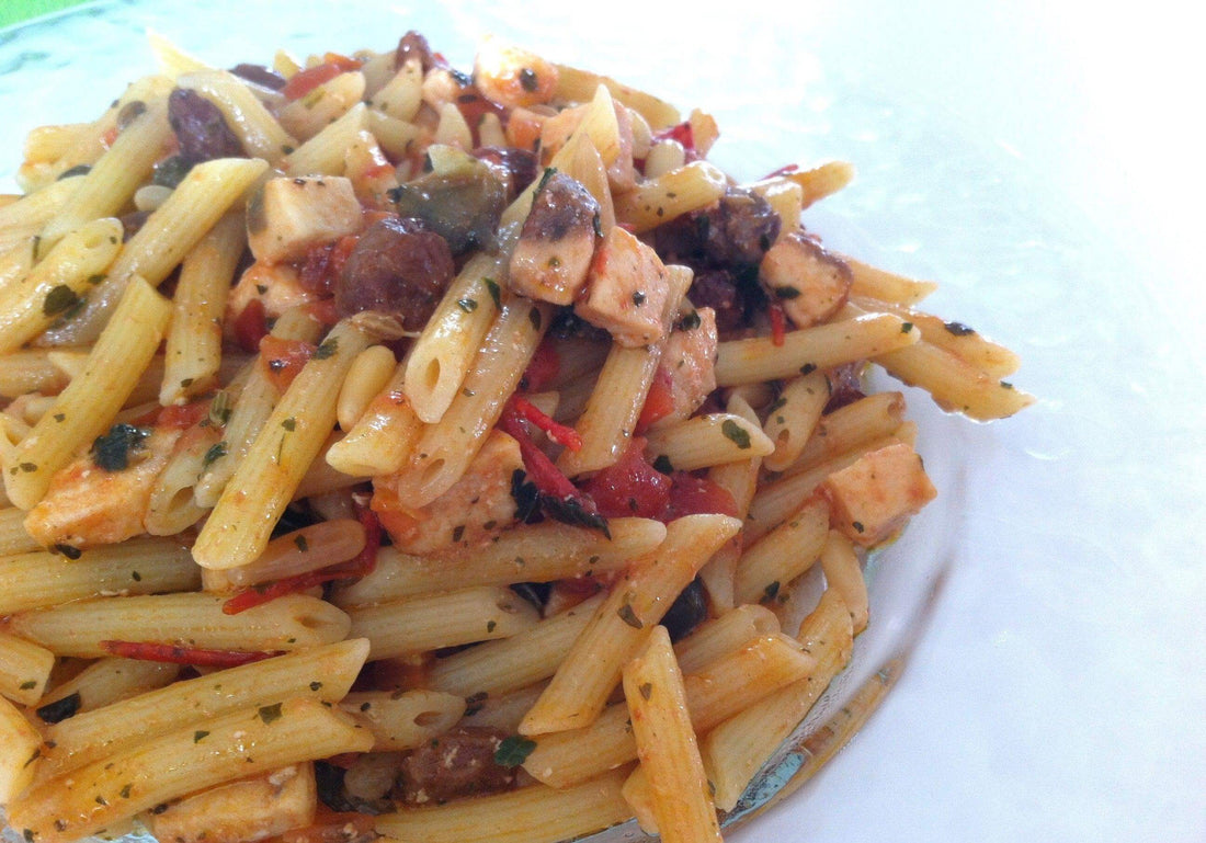 Delicious penne pasta with fish, tomatoes, and herbs, showcasing a vibrant Italian dish.