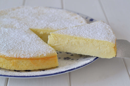 Delicious torta di ricotta, a creamy ricotta cake dusted with powdered sugar, with a slice cut out.