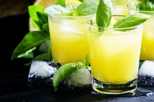 Refreshing bergamot punch in glasses, garnished with basil, served over ice.