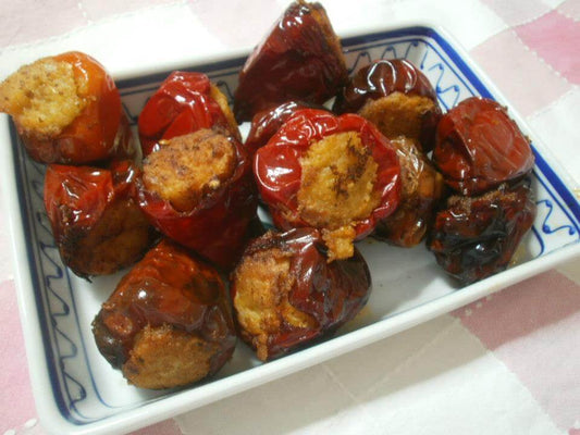 Plate of stuffed Calabrian peppers filled with breadcrumb mixture, showcasing a traditional Italian dish.
