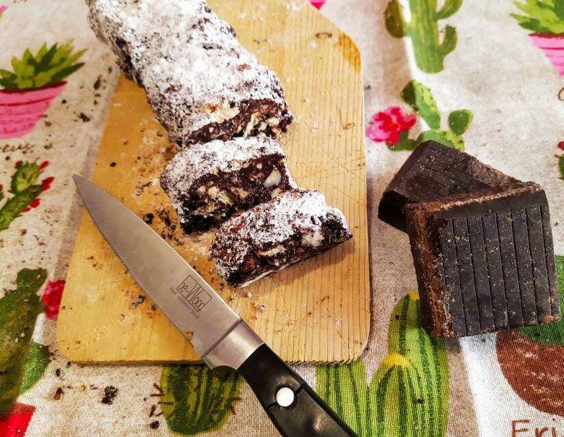 Delicious sliced Salame di Cioccolato on a cutting board, showcasing rich chocolate and nut textures.