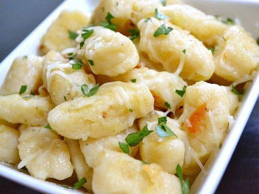 Delicious Gnocchetti Sardi alla Ricotta Affumicata garnished with parsley in a white bowl.