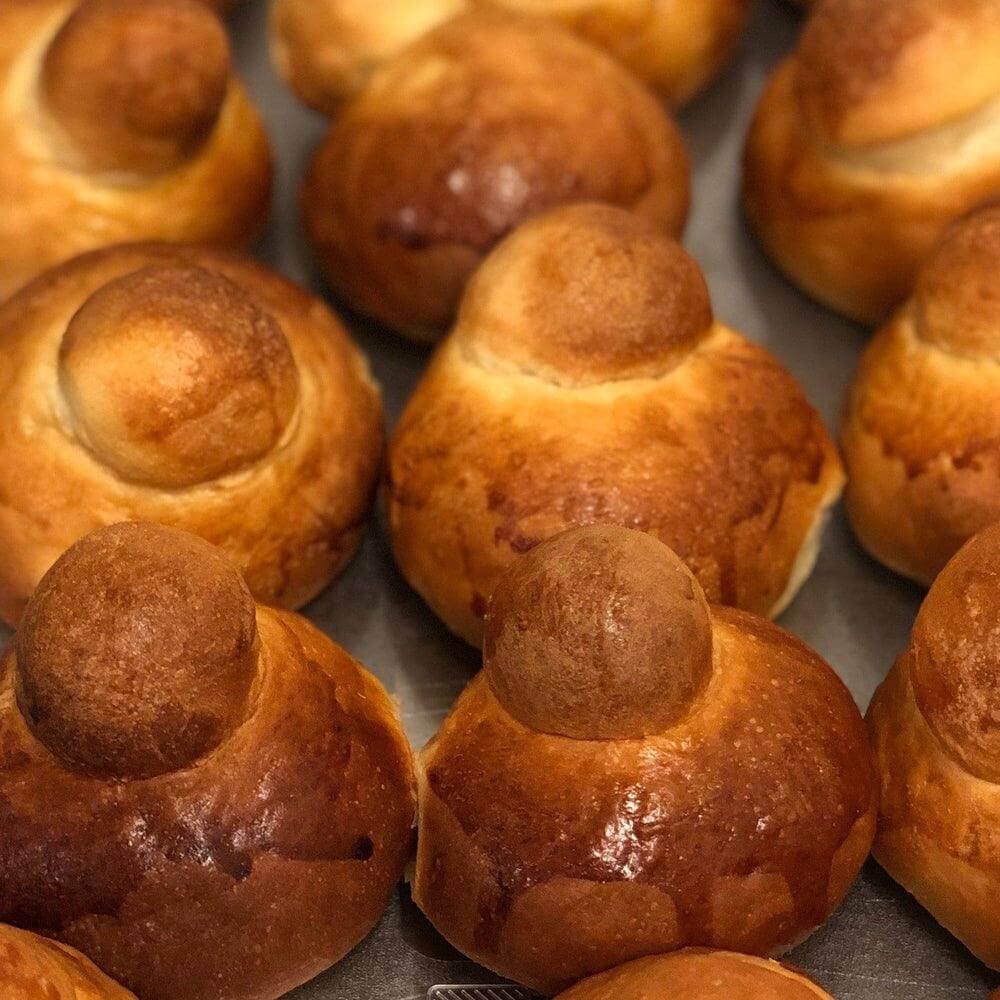 Delicious Sicilian and Calabrian brioche col tuppo, golden brown and freshly baked, perfect for gelato and treats.