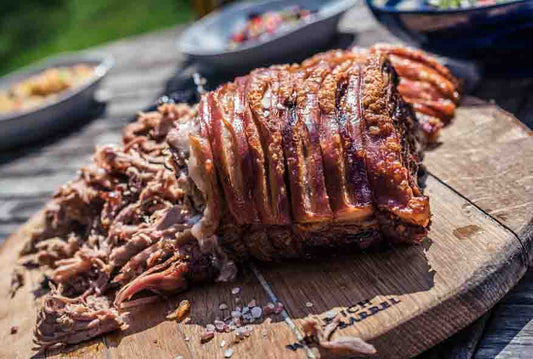 Pulled Porck succulento su un tagliere di legno, ideale per cene eleganti e momenti conviviali.