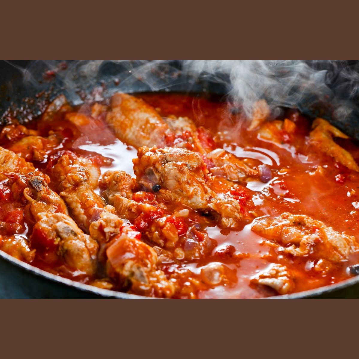 Ragù di maiale pronto alla calabrese in una pentola, carne suina cucinata in salsa di pomodoro, fumante e ricca.